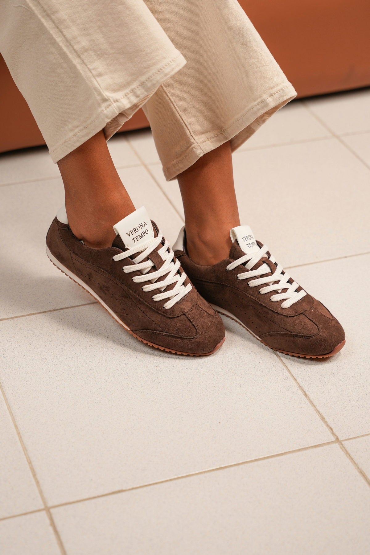 Brown suede Verona Tempo trainers worn with cream linen trousers