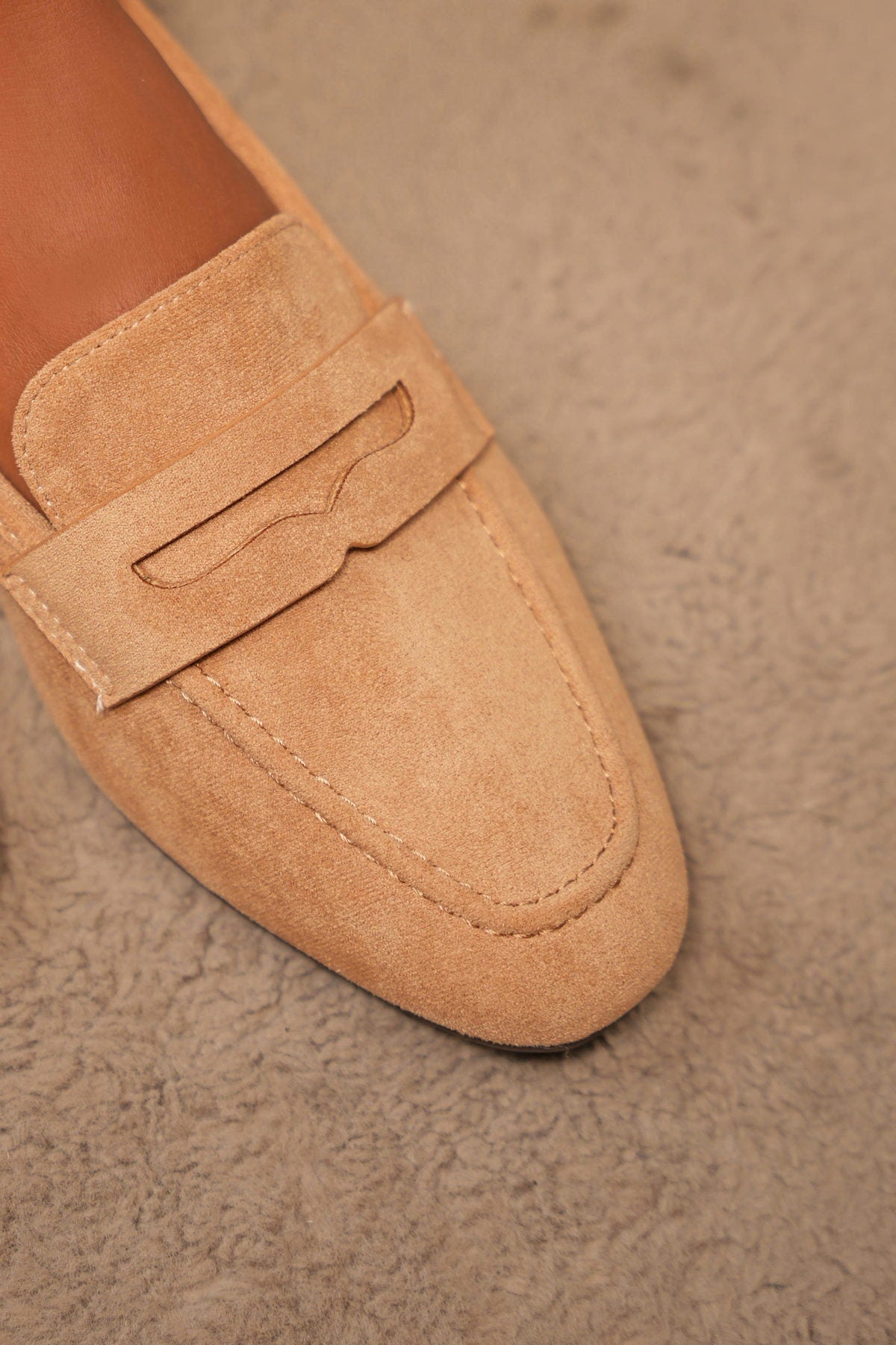 Close-up of a tan suede penny loafer
