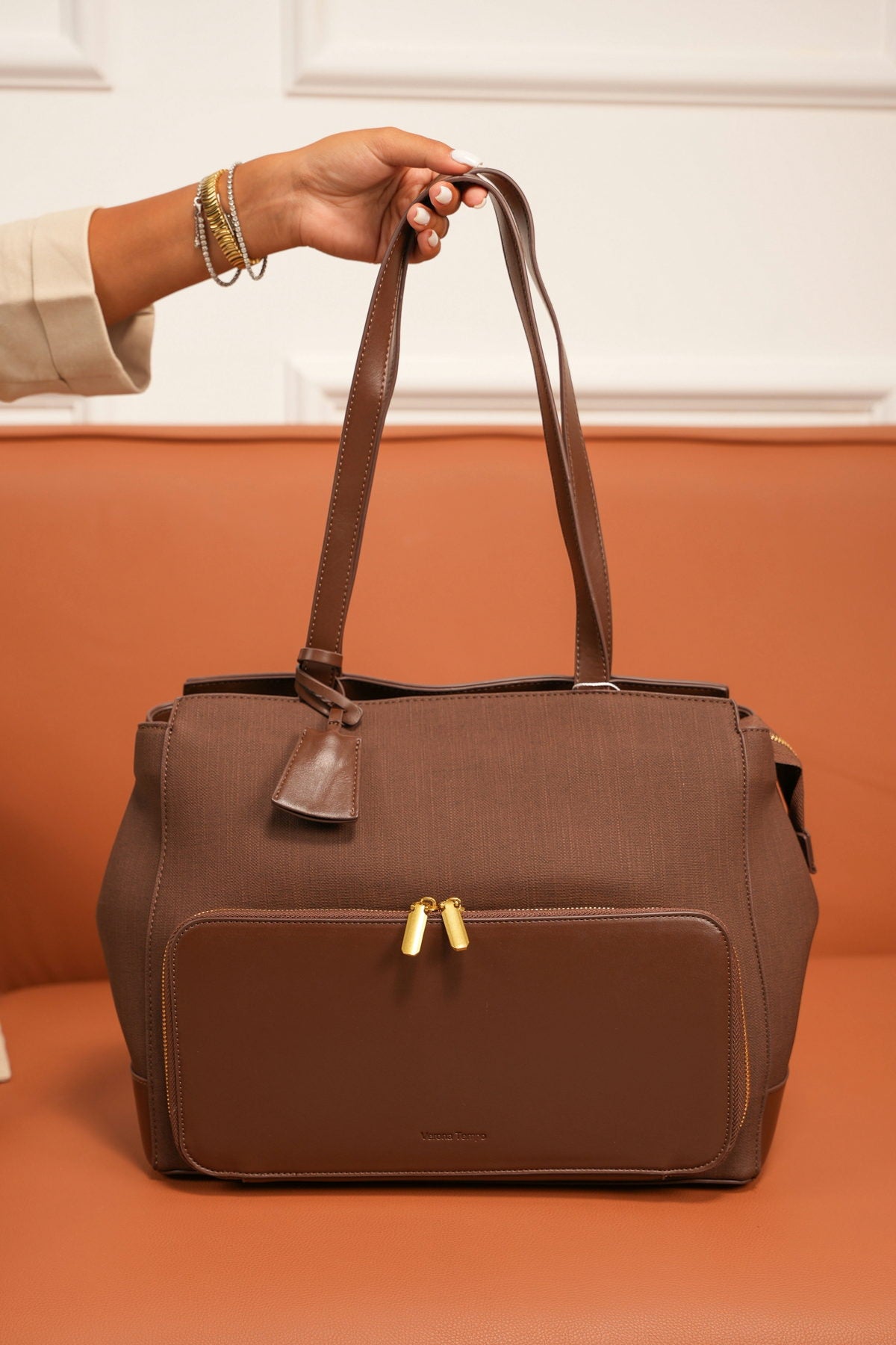 Brown leather Verona Tempo holdall bag on a terracotta couch